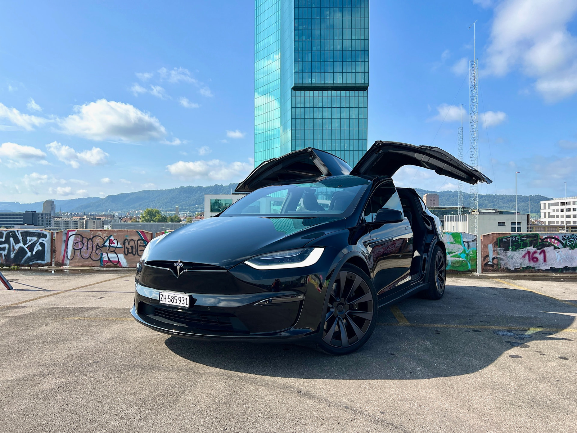 Schwarzer Tesla Model X Plaid mit offenen Flügeltüren vor dem Prime Tower in Zürich