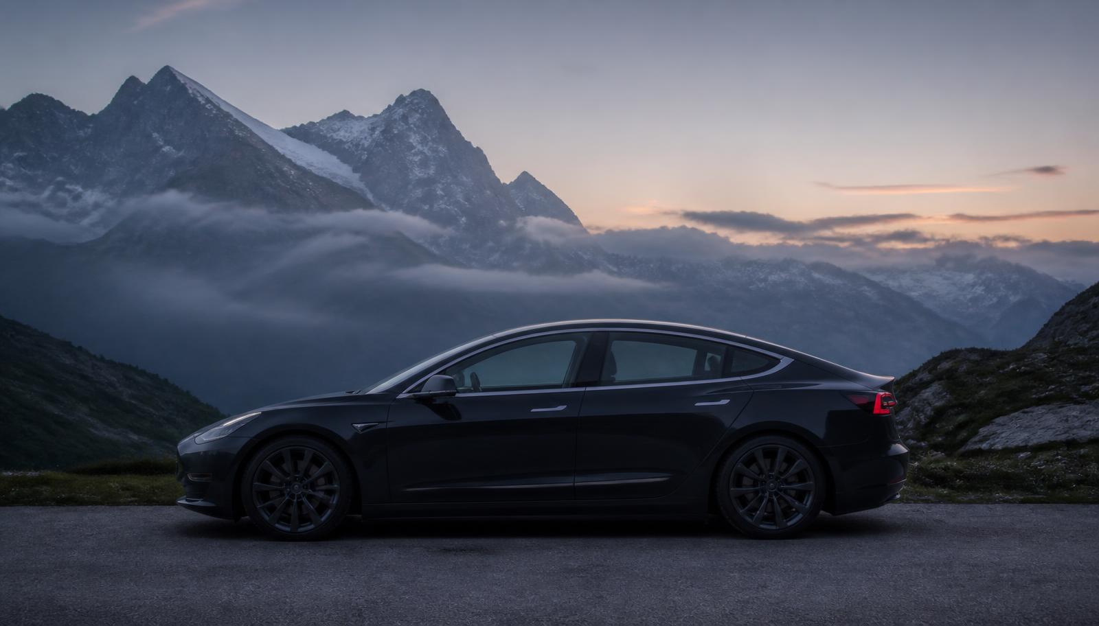 Tesla ohne Werbeaufschrift vor Schweizer Bergkulisse im Abendlicht