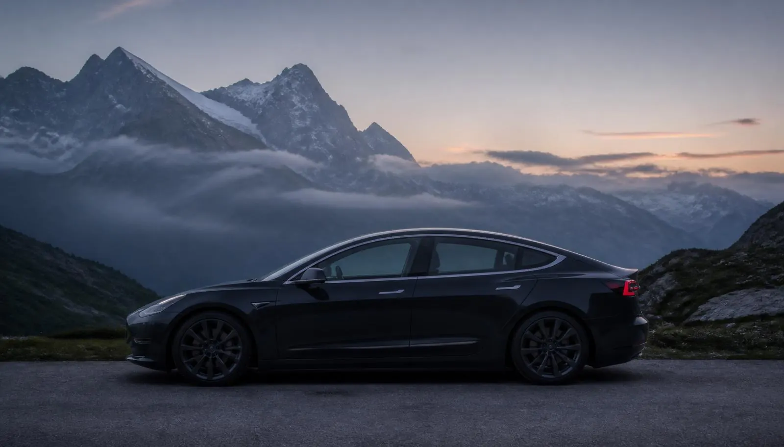 Tesla ohne Werbeaufschrift vor Schweizer Bergkulisse im Abendlicht